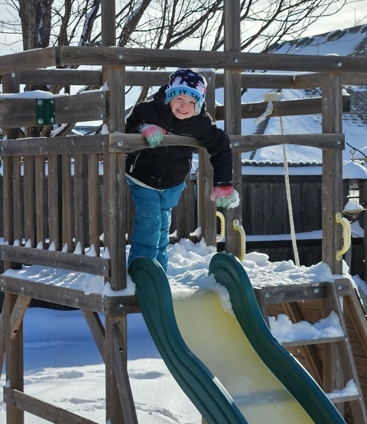 student on play set in the snow