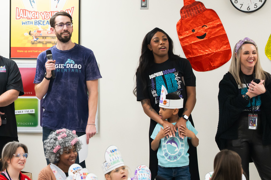 adults watching and smiling during an addembly 