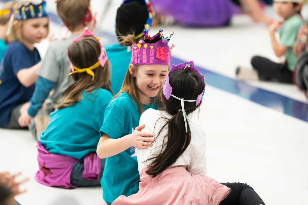 kids hugging at an assembly