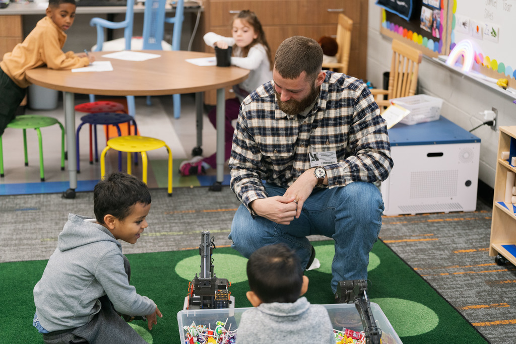 adult helping child use a toy