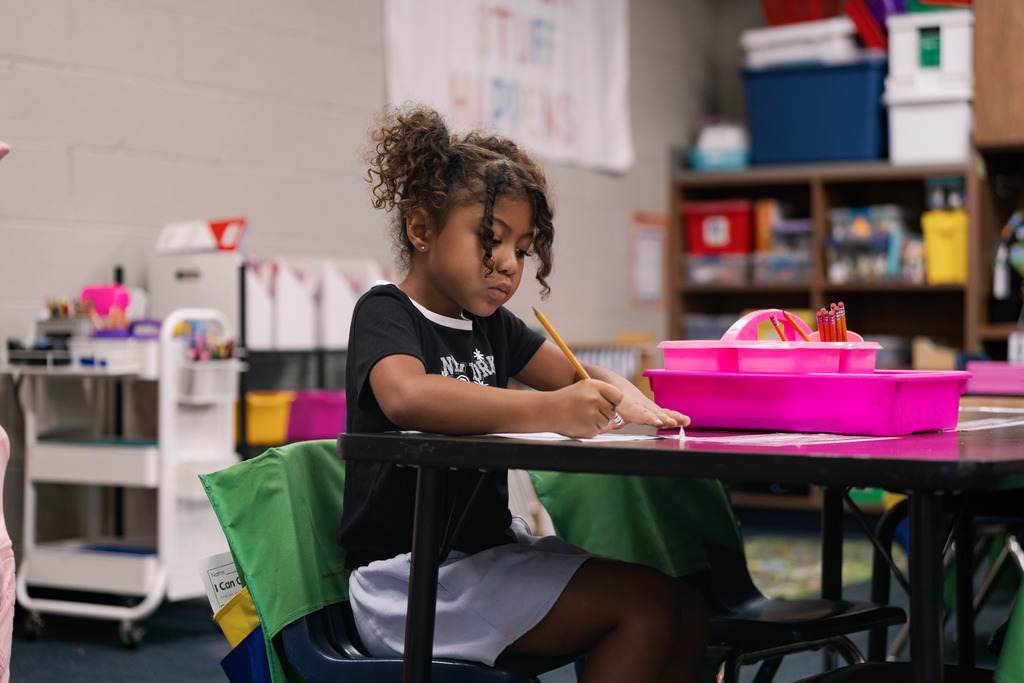 girl writing something down at her desk