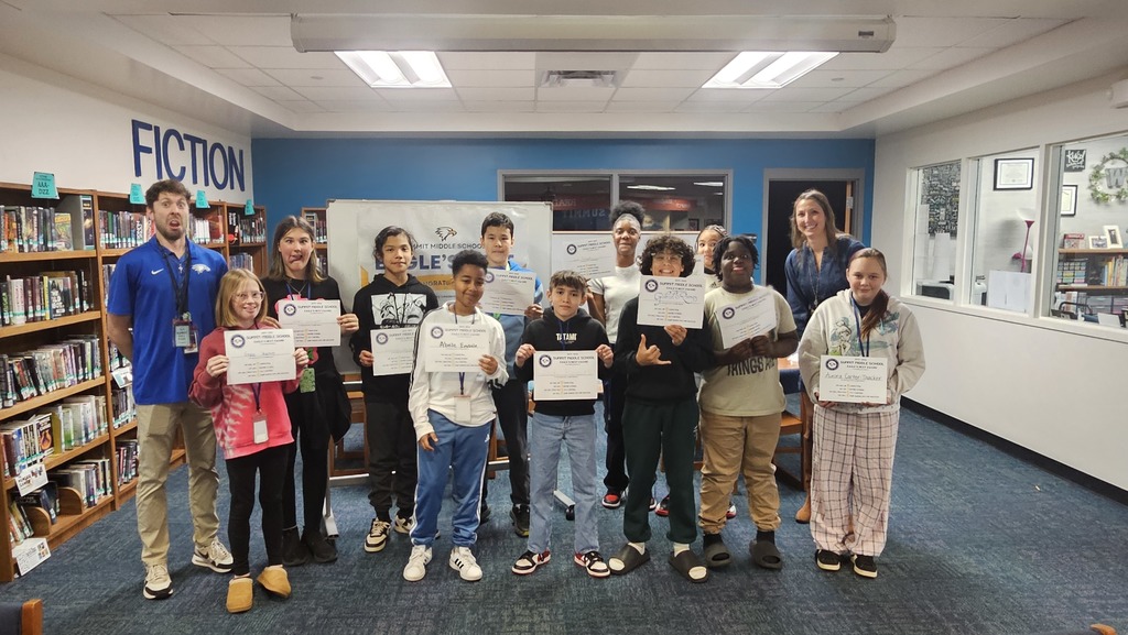 6th grade Eagles Nest recipients stand together smiling and holding their awards.