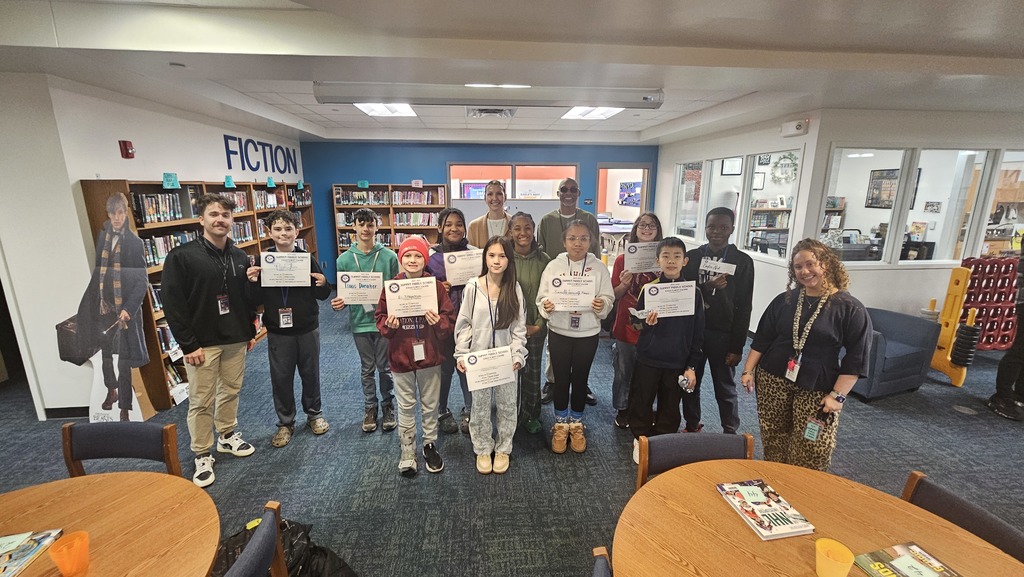 6th grade Eagles Nest recipients stand together smiling and holding their awards.