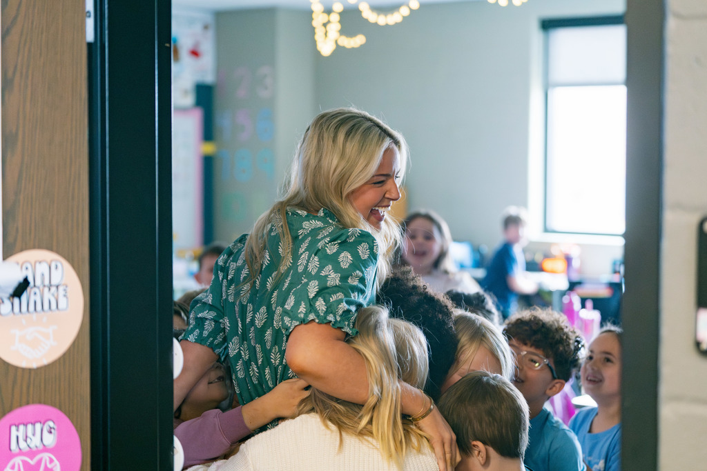 emma hugging students and smiling