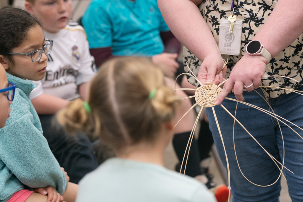 students weaving baskets in a classroom
