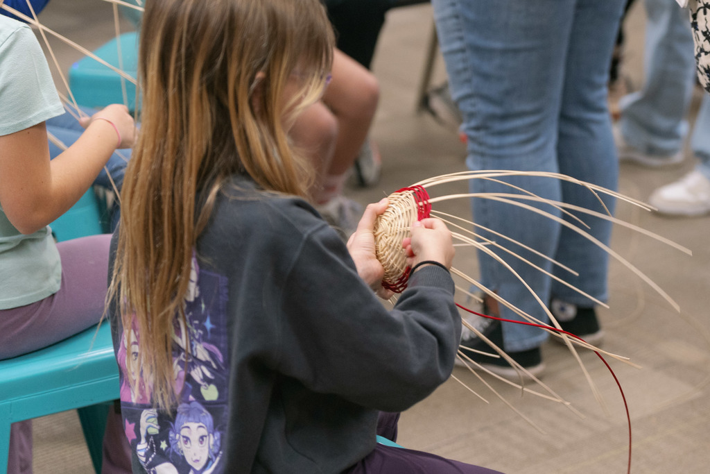 students weaving baskets in a classroom