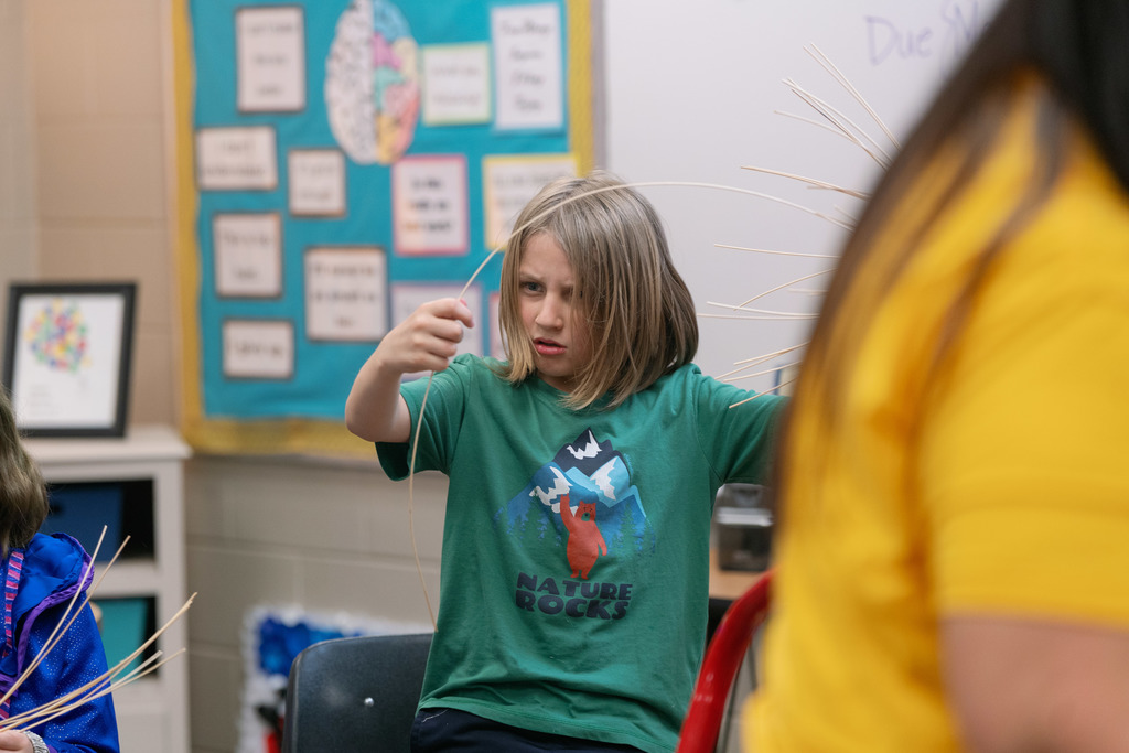 students weaving baskets in a classroom