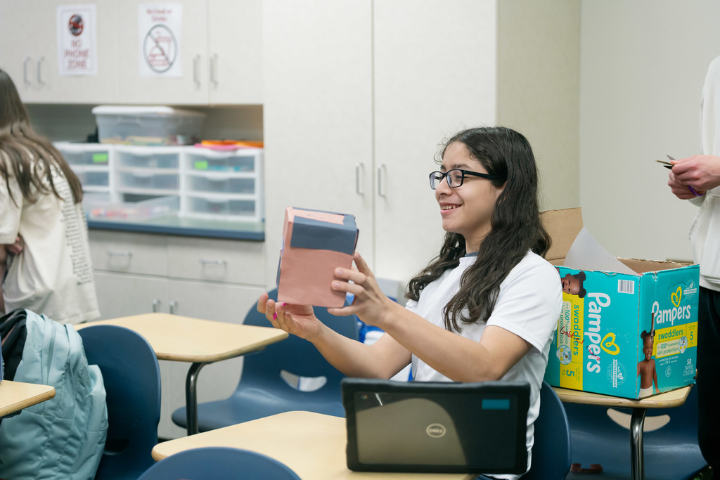 boy holding up a box and smiling