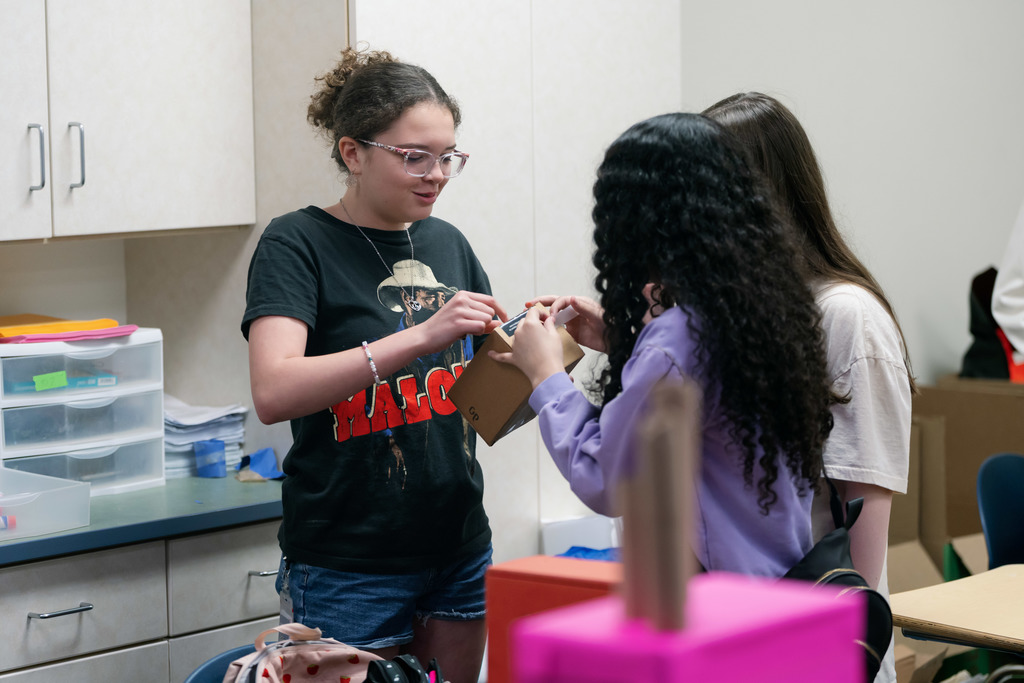 girls working together on a box