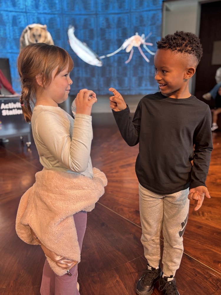 students playing an indigenous iteration of rock paper scissors at fam 