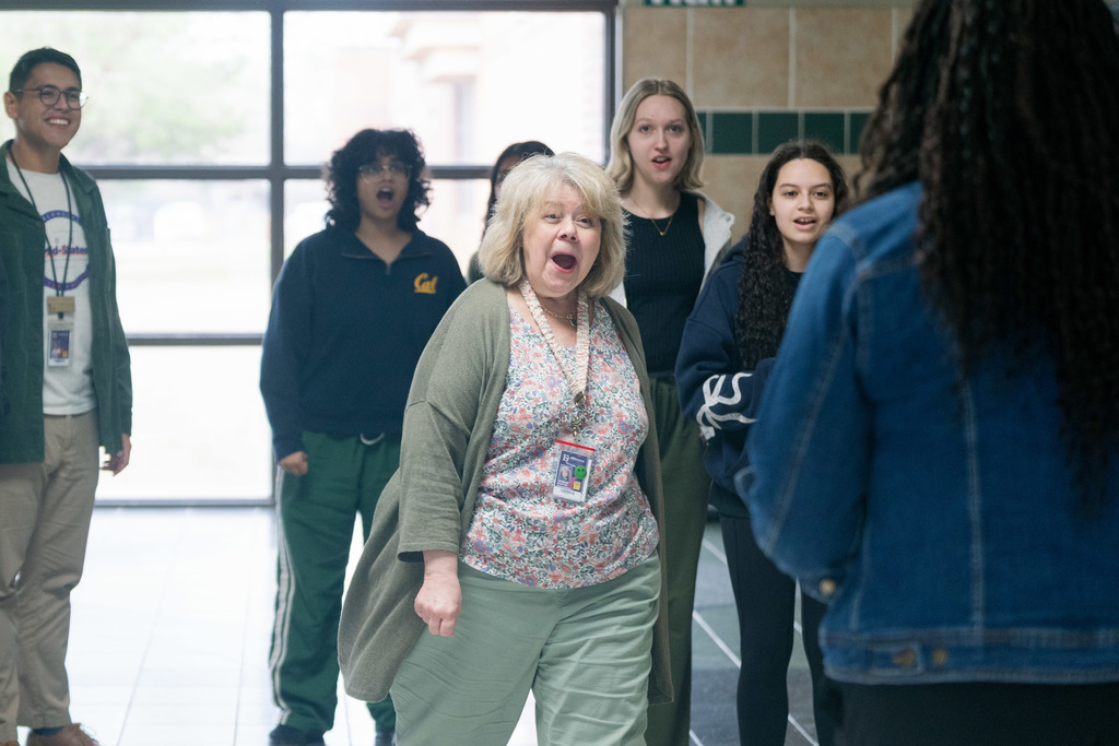 woman being surprised with an award in a high school