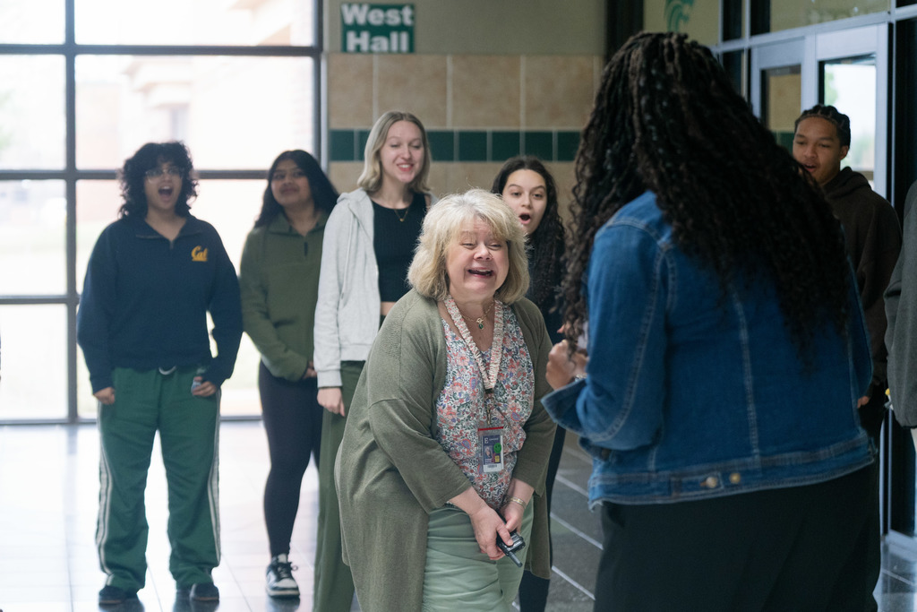 woman being surprised with an award in a high school