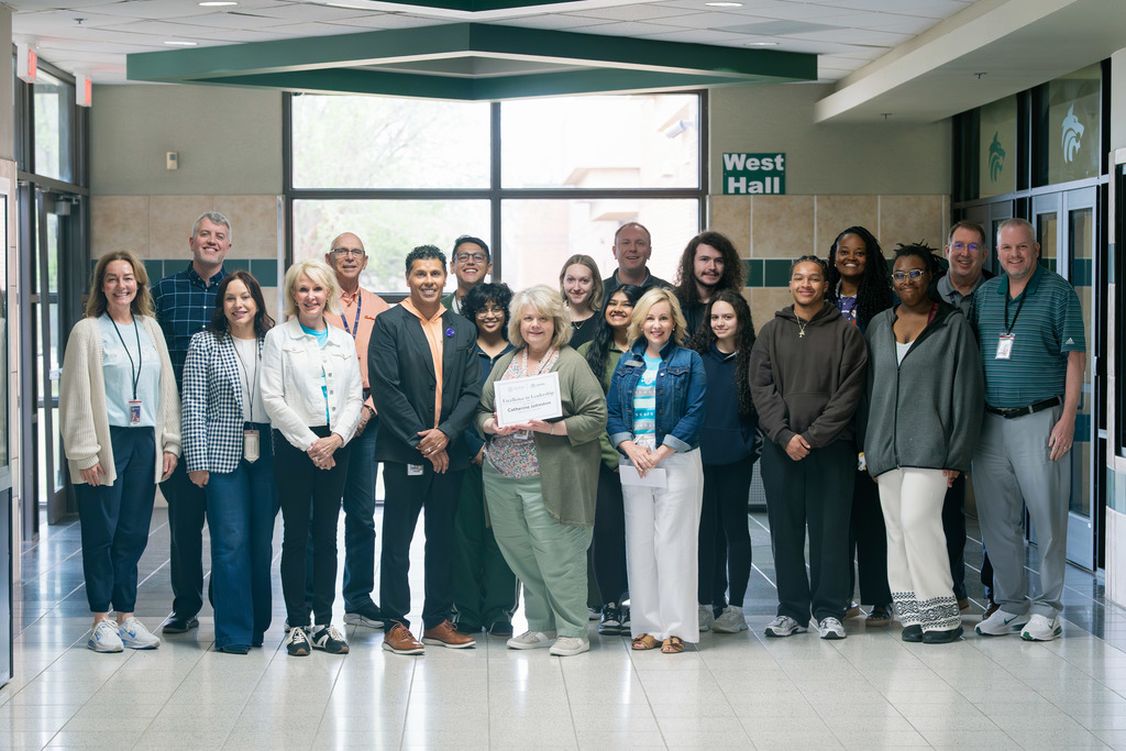 award recipient standing with administrators and students