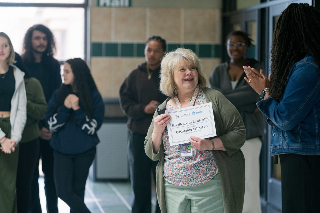 woman being surprised with an award in a high school