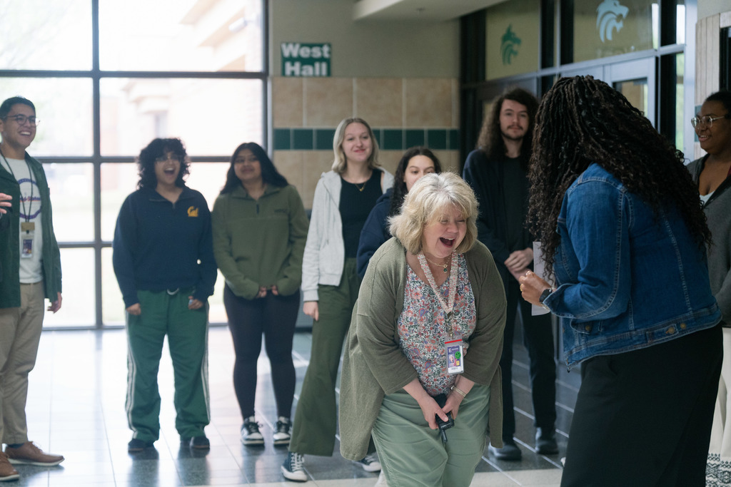 woman being surprised with an award in a high school