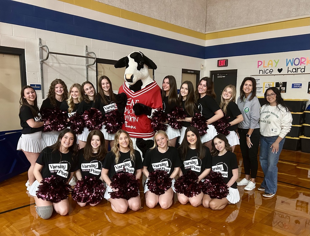 pom members standing with the chick fil a cow