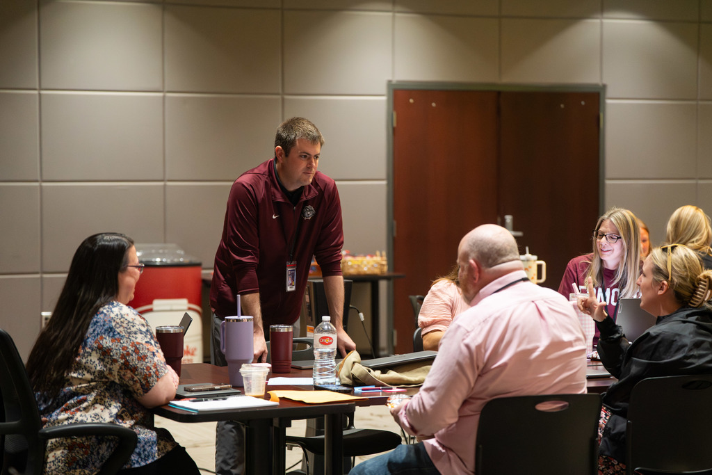 group of teachers talking at a table
