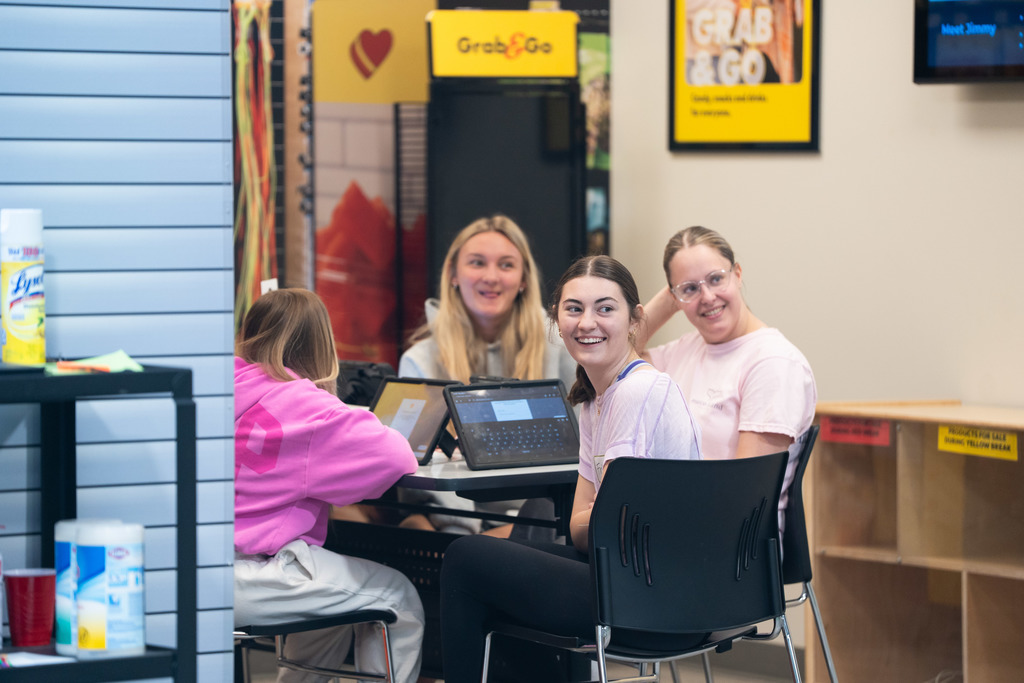 students sitting at a table laughing