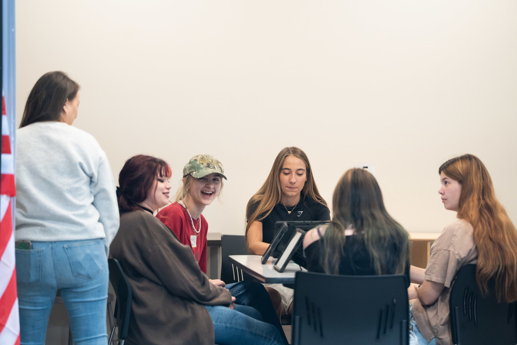 students sitting at a table laughing
