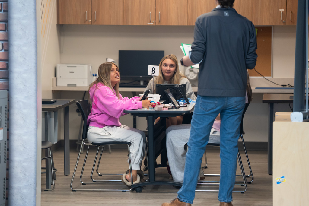 students listening to a volunteer speak