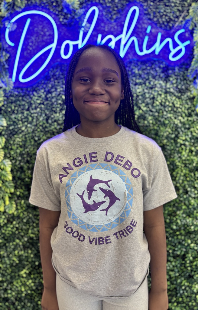 student in front of green backdrop with neon sign