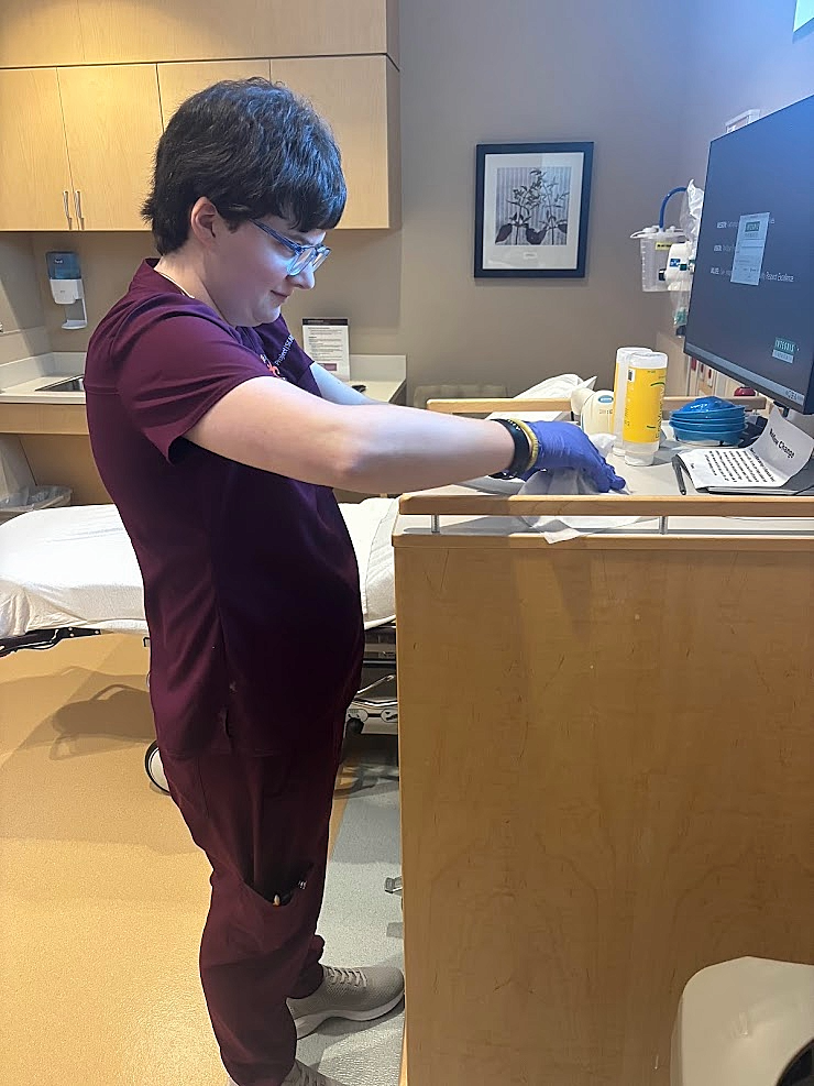 An intern sanitizing a triage room