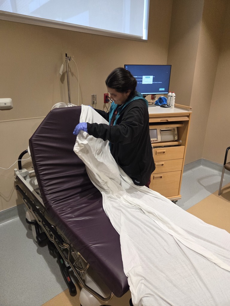 An intern managing linens in patient rooms