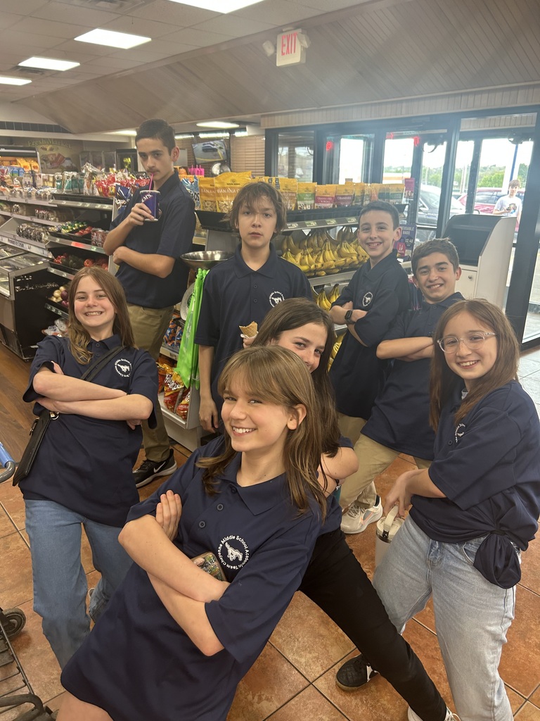 8 teens posing in a convenience store