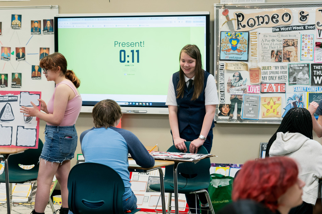 student presenting to another student in a classroom