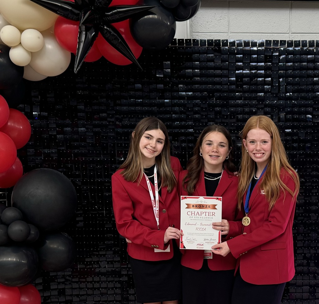 Standing left to right are Chesney, Anna, and Elizabeth. The three student are standing in front of a sparkly black photo backdrop framed with black, gold, and red balloons. Students are holding the certificate they received for being a Bronze Level FCCLA Chapter. 