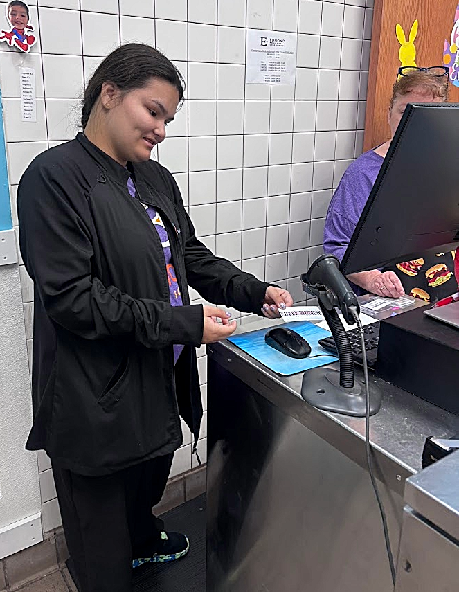 An intern scanning a barcode at checkout. 