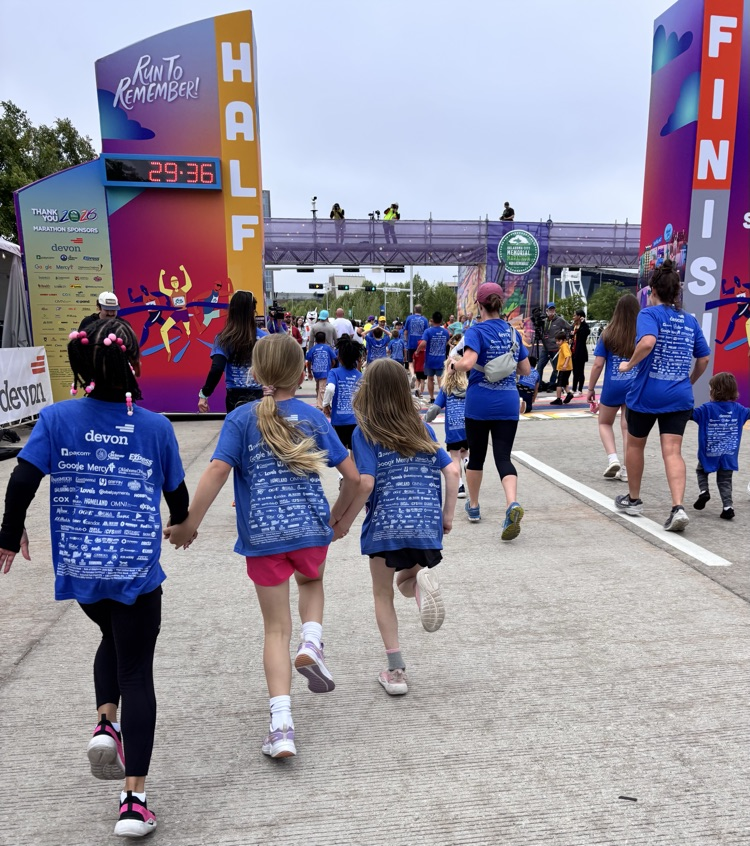 students holding hands crossing the finish line 
