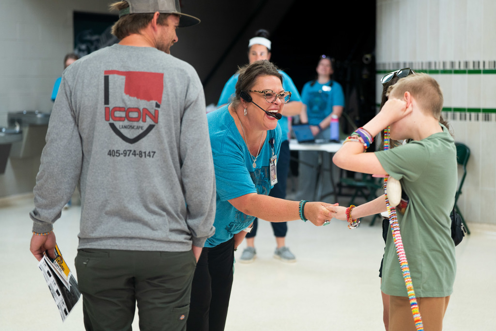 woman shaking child's hand and laughing