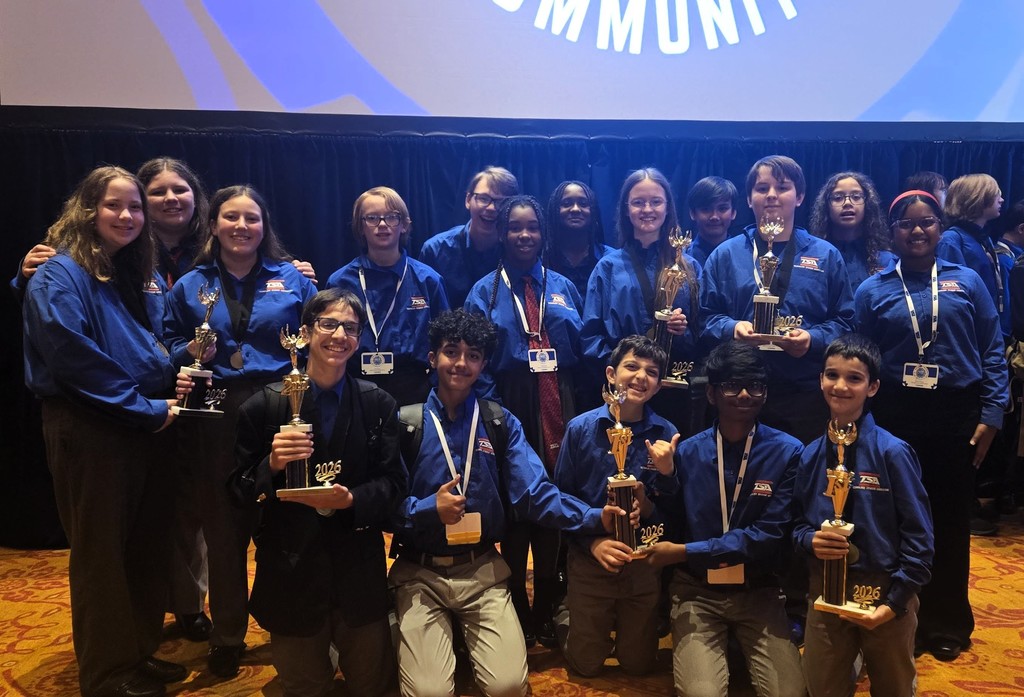Summit TSA team members stand together in a group holding the trophies and metals they won at State Conference.