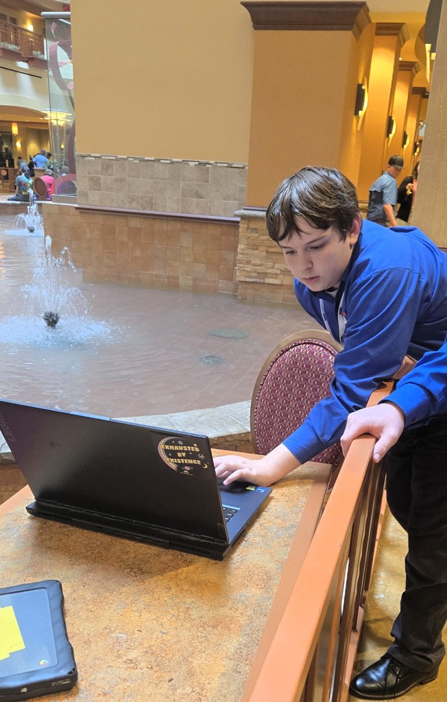Nathan is working on a laptop while at State Conference.