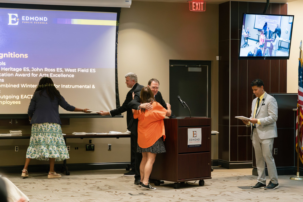 reiree with their plaque shaking hands of board members