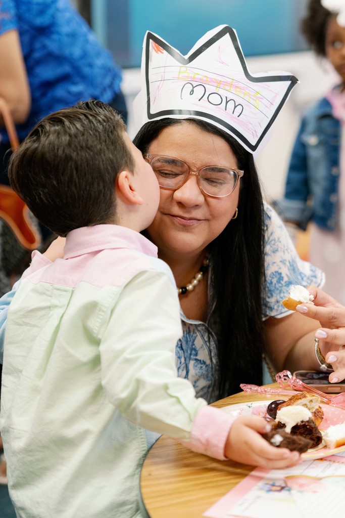 boy giving his mom a kiss on the cheek