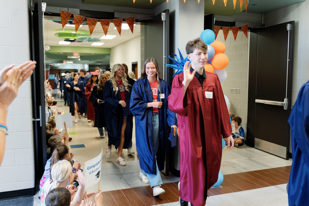 students walking halls with caps and gowns