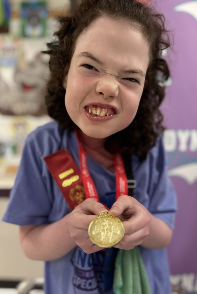 student smiling with gold medal 