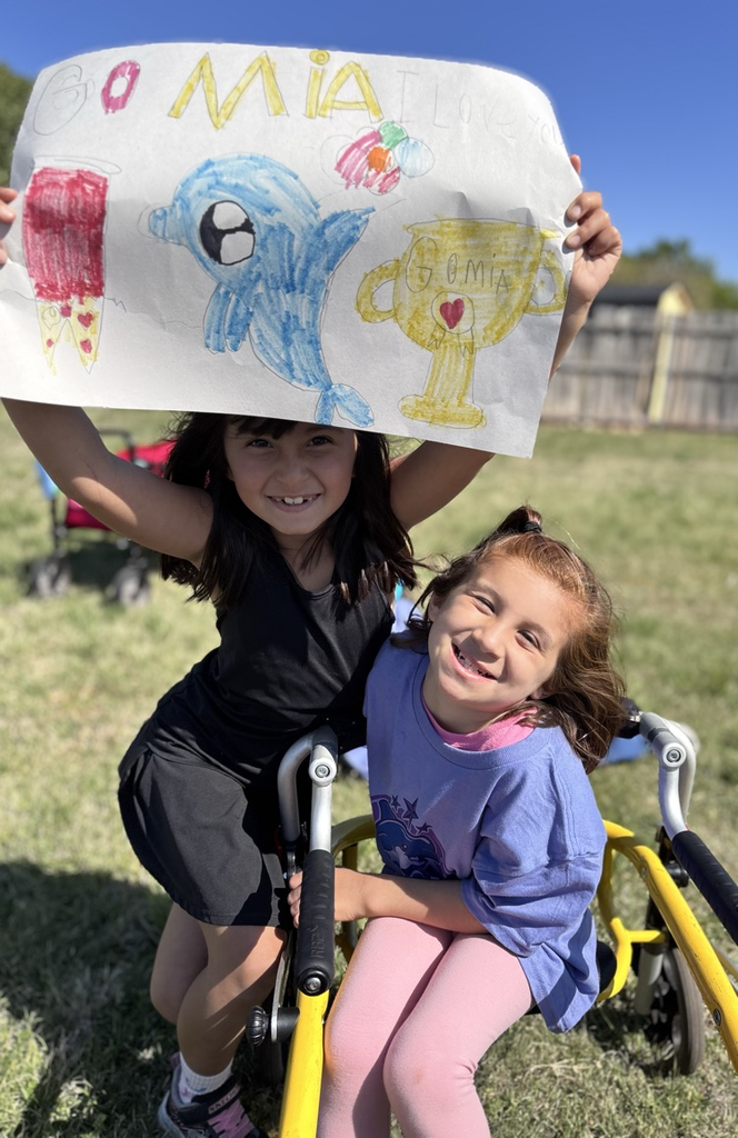 student and sister with a sign 