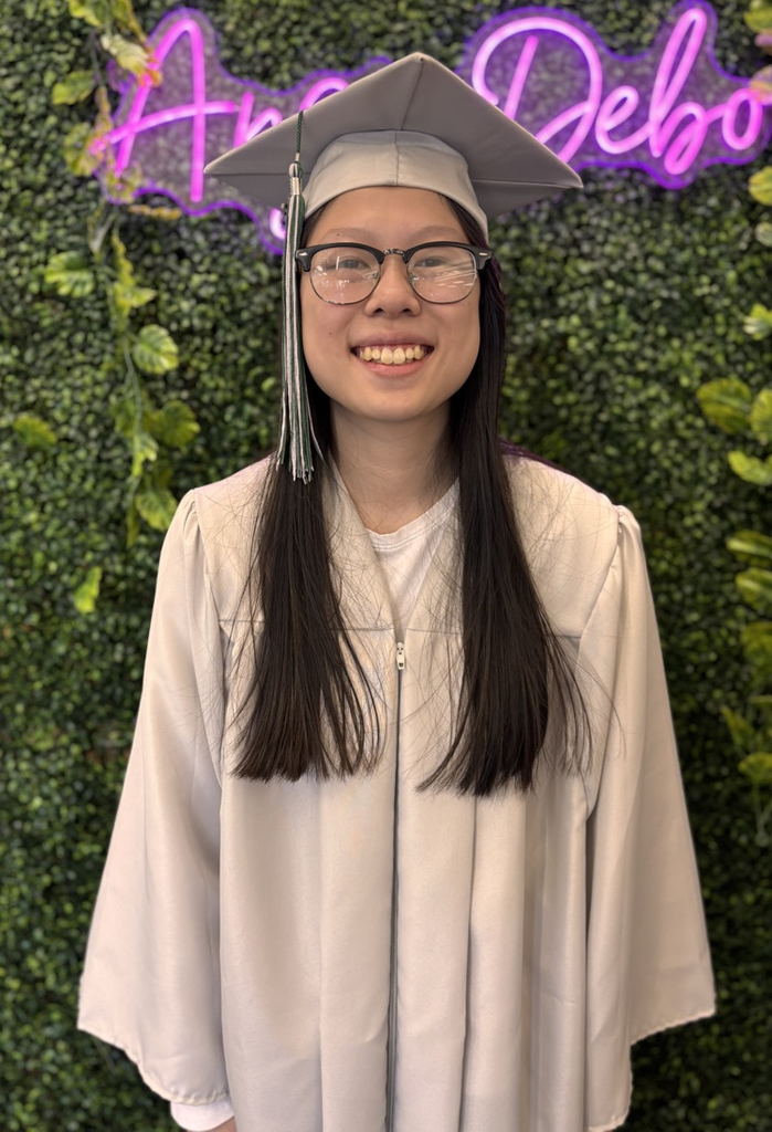 senior in front of faux greenery 