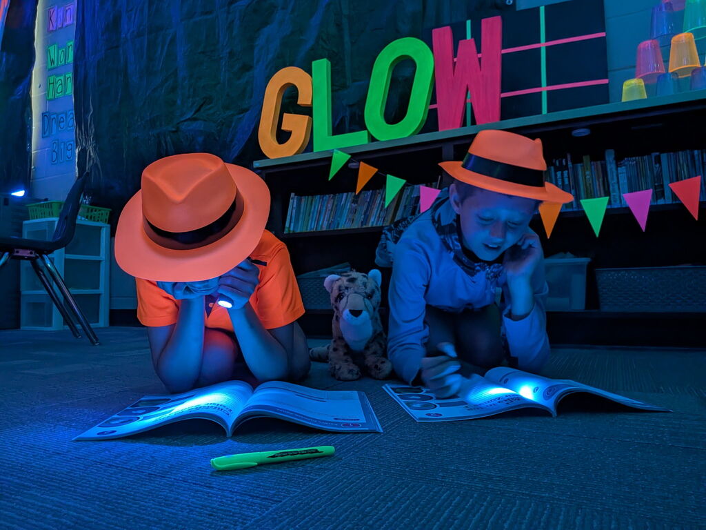 students reading in the dark for "Glow What You Know"