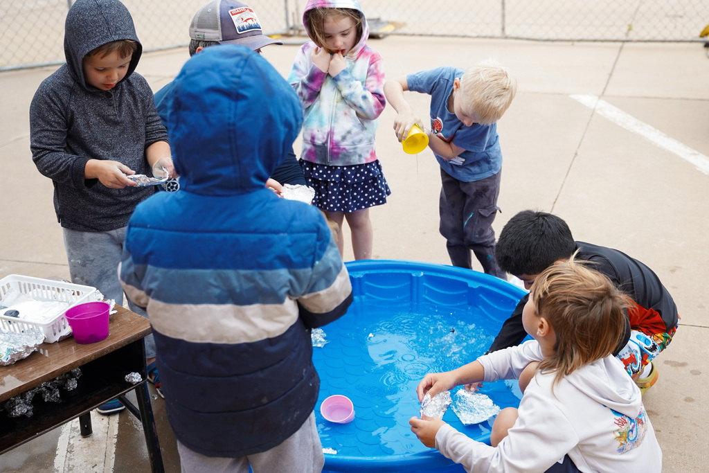 young students playing with water