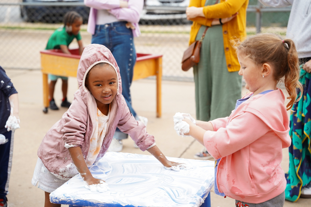 young student playing with shaving cream