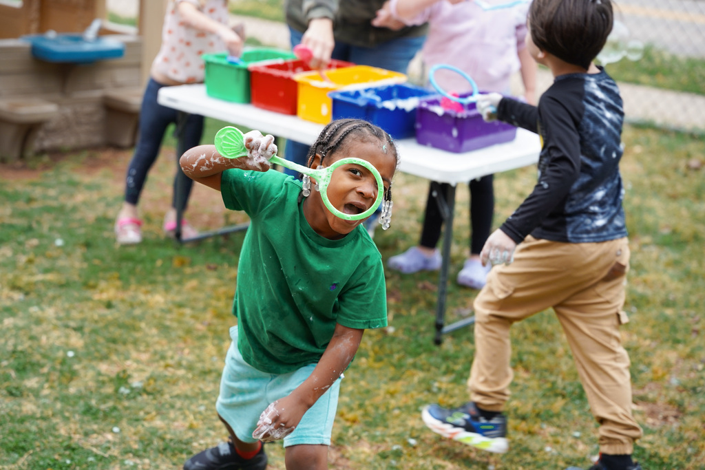 young student playing with bubbles