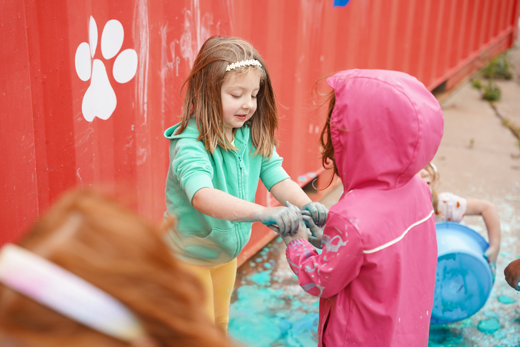 young students playing with chalk and water