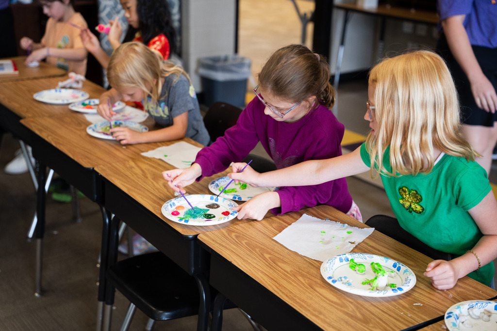 student painting a clay mold of an animal