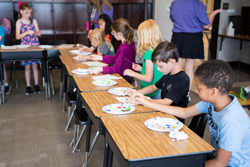 student painting a clay mold of an animal