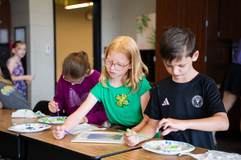 student painting a clay mold of an animal