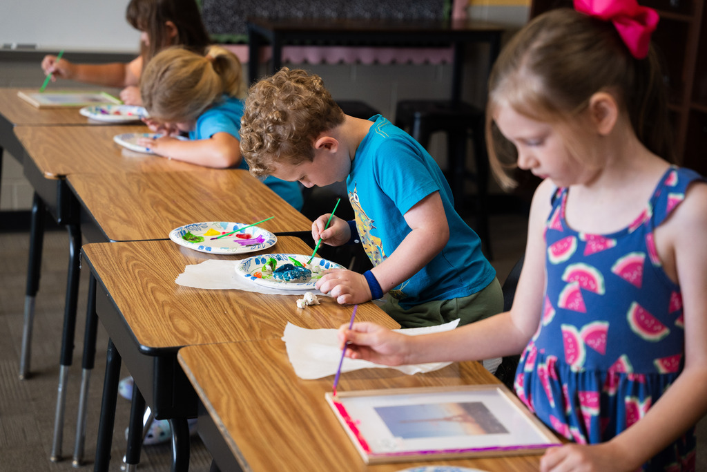 student painting a clay mold of an animal